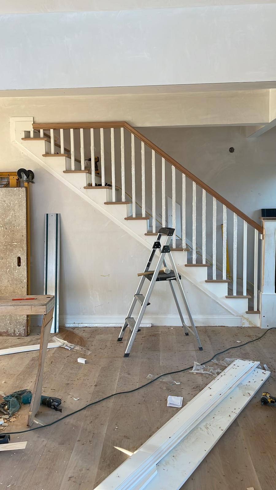 Before and after photo of stair trim installation inside a house by Victor's Finish Work