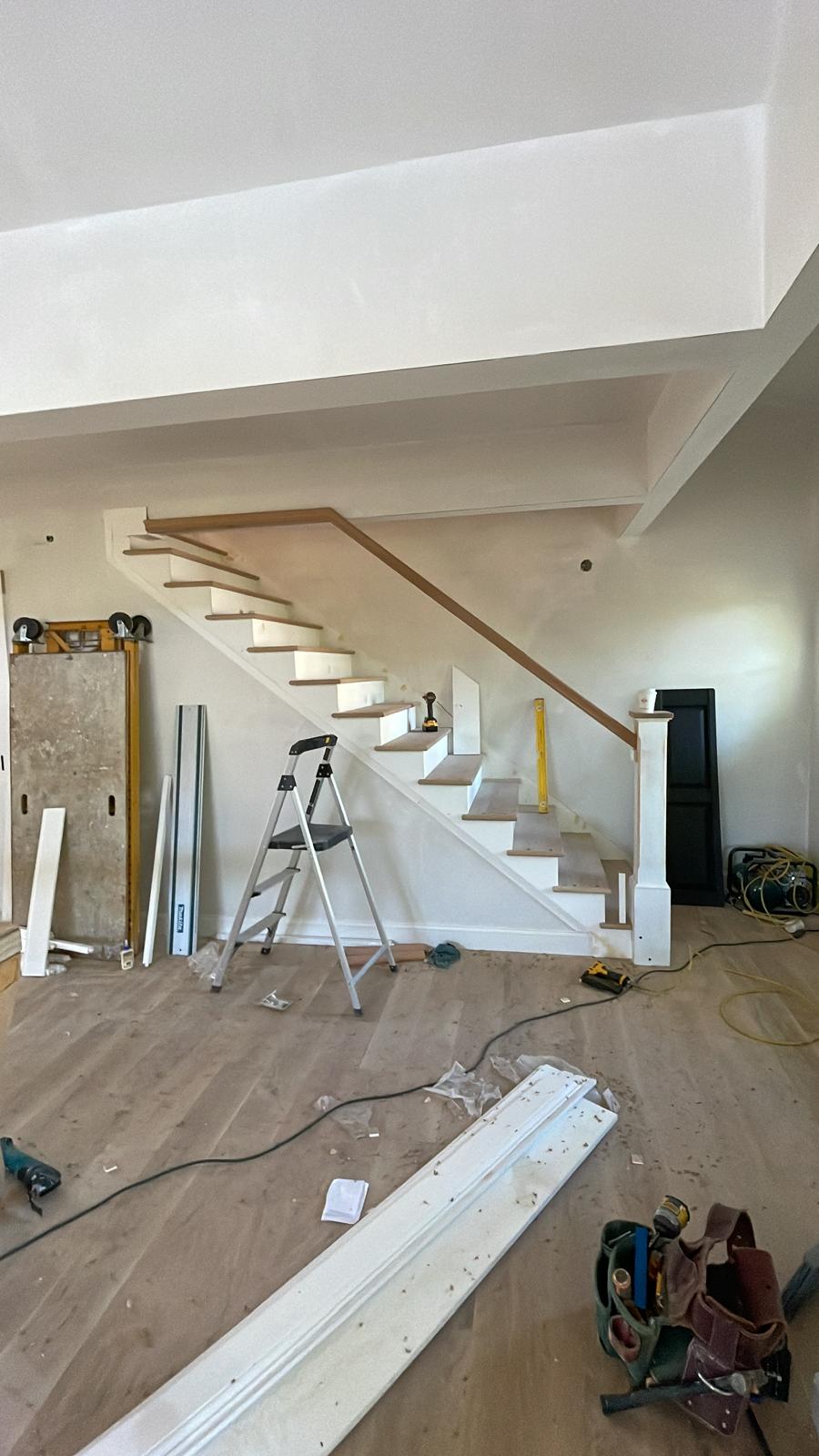 Before and after photo of stair trim installation inside a house by Victor's Finish Work